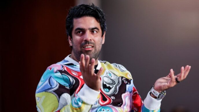 Sachin Dev Duggal raises his hands in a gesture as he speaks