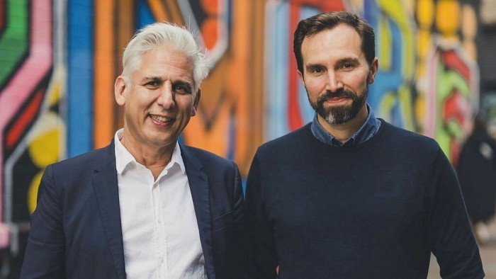 Robin Tuluie, left, and Jacomo Corbo standing in front of a colourfully painted wall