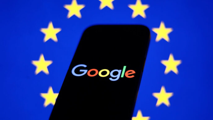 European Union flag displayed on a laptop screen and Google logo displayed on a phone in front of it