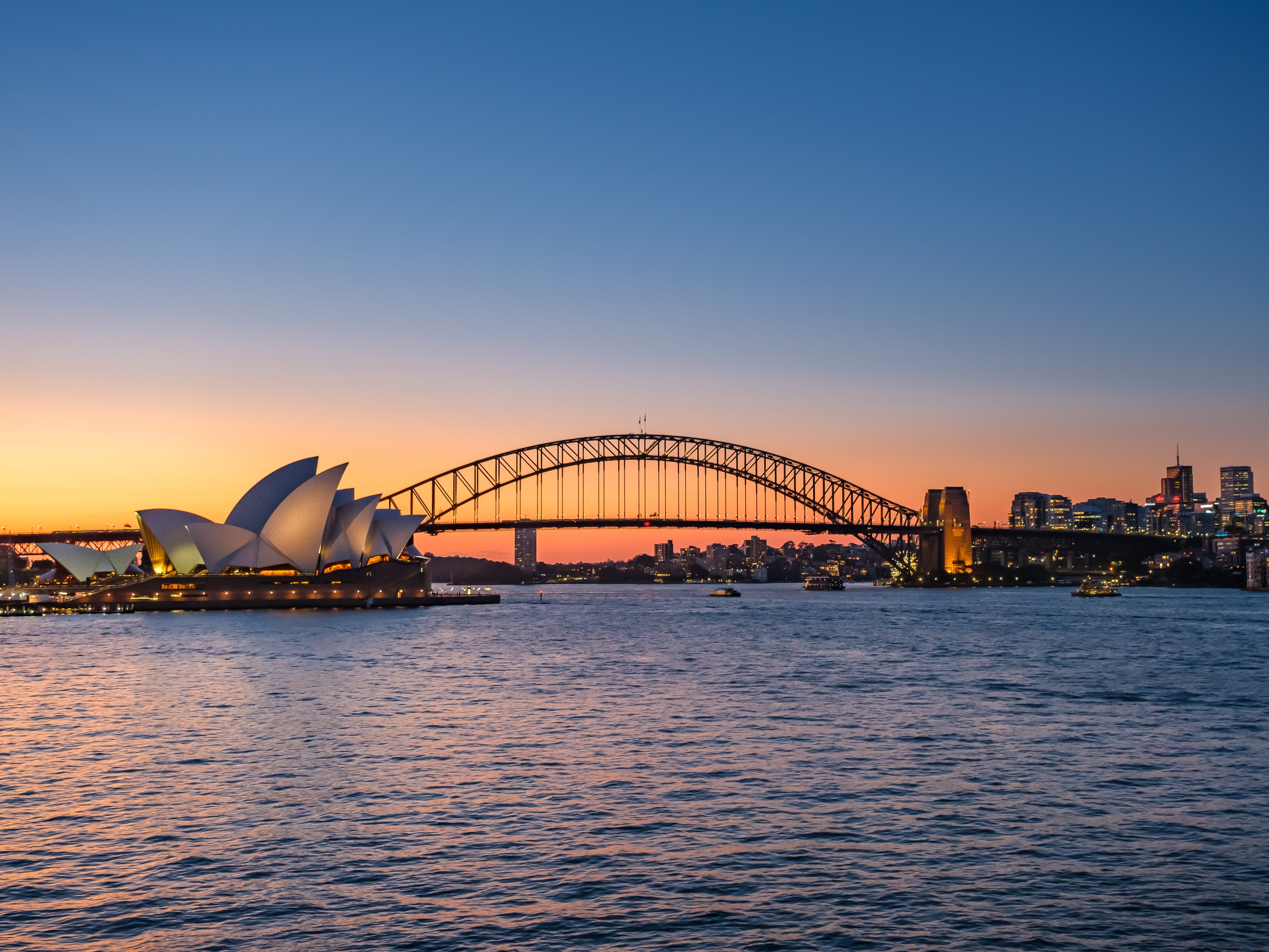 The view of Sydney Harbour — with the Sydney Opera House and Sydney Harbour Bridge — at sunset.