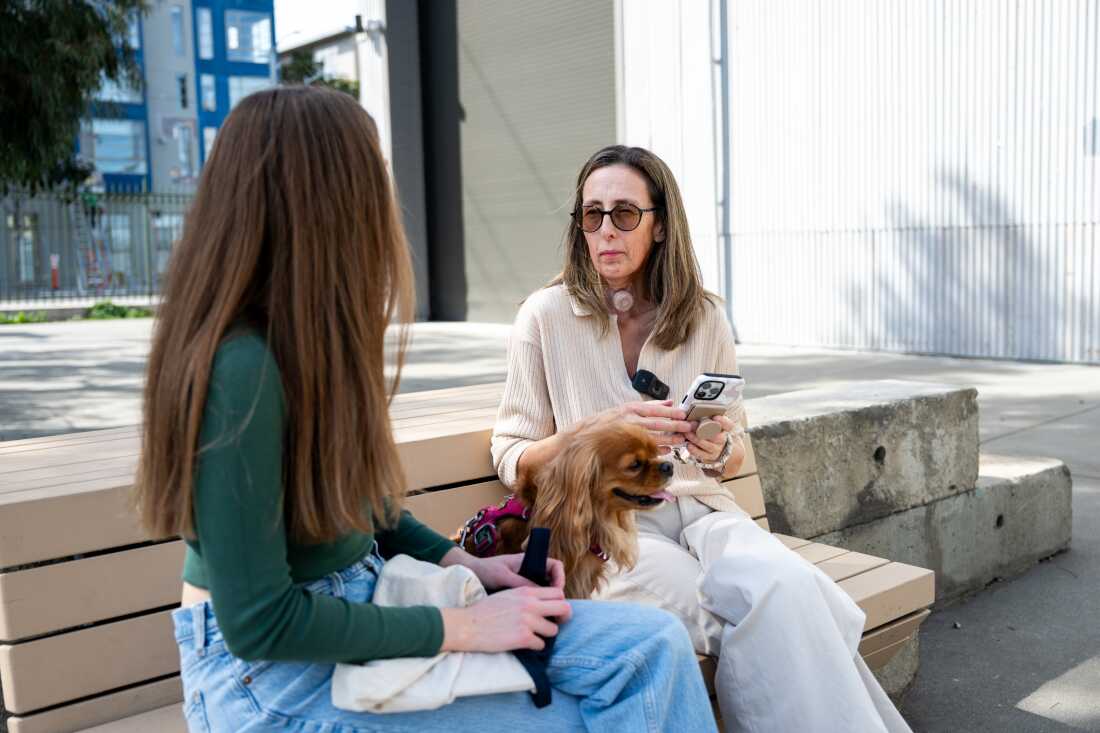 Sonya Sotinsky uses an app on her phone to talk with her daughter Ela Fuentevilla at Crane Cove Park in San Francisco on March 25, 2025.