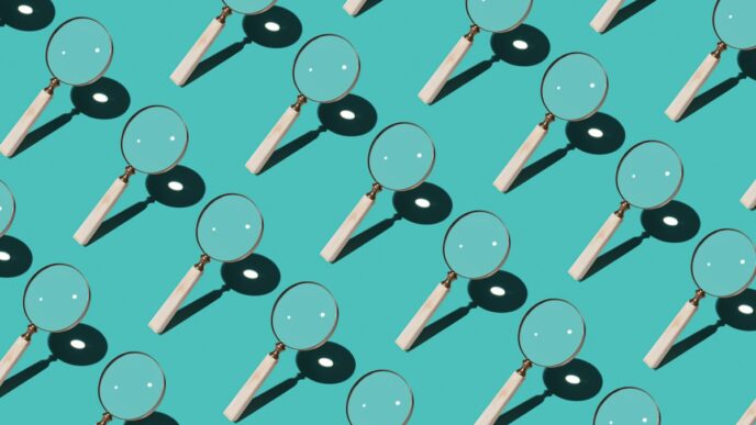 Magnifying Glass Focusing Sunlight Into a Point Repetition on Turquoise Colored Background High Angle View.